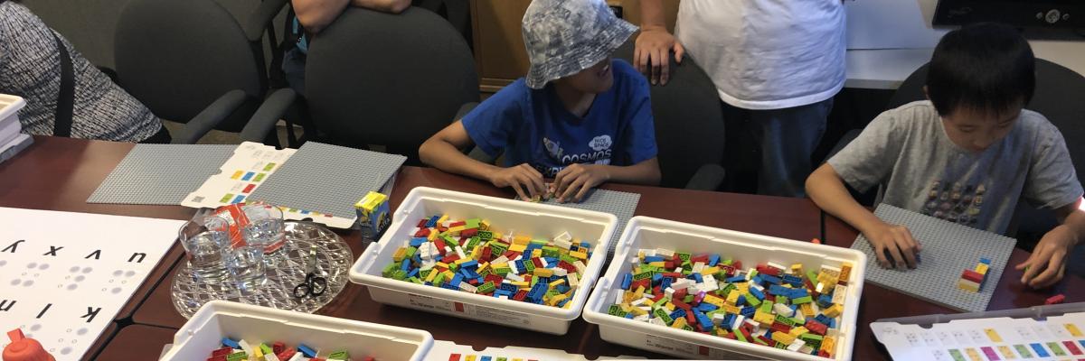 Des enfants jouent avec des blocs LEGO en braille