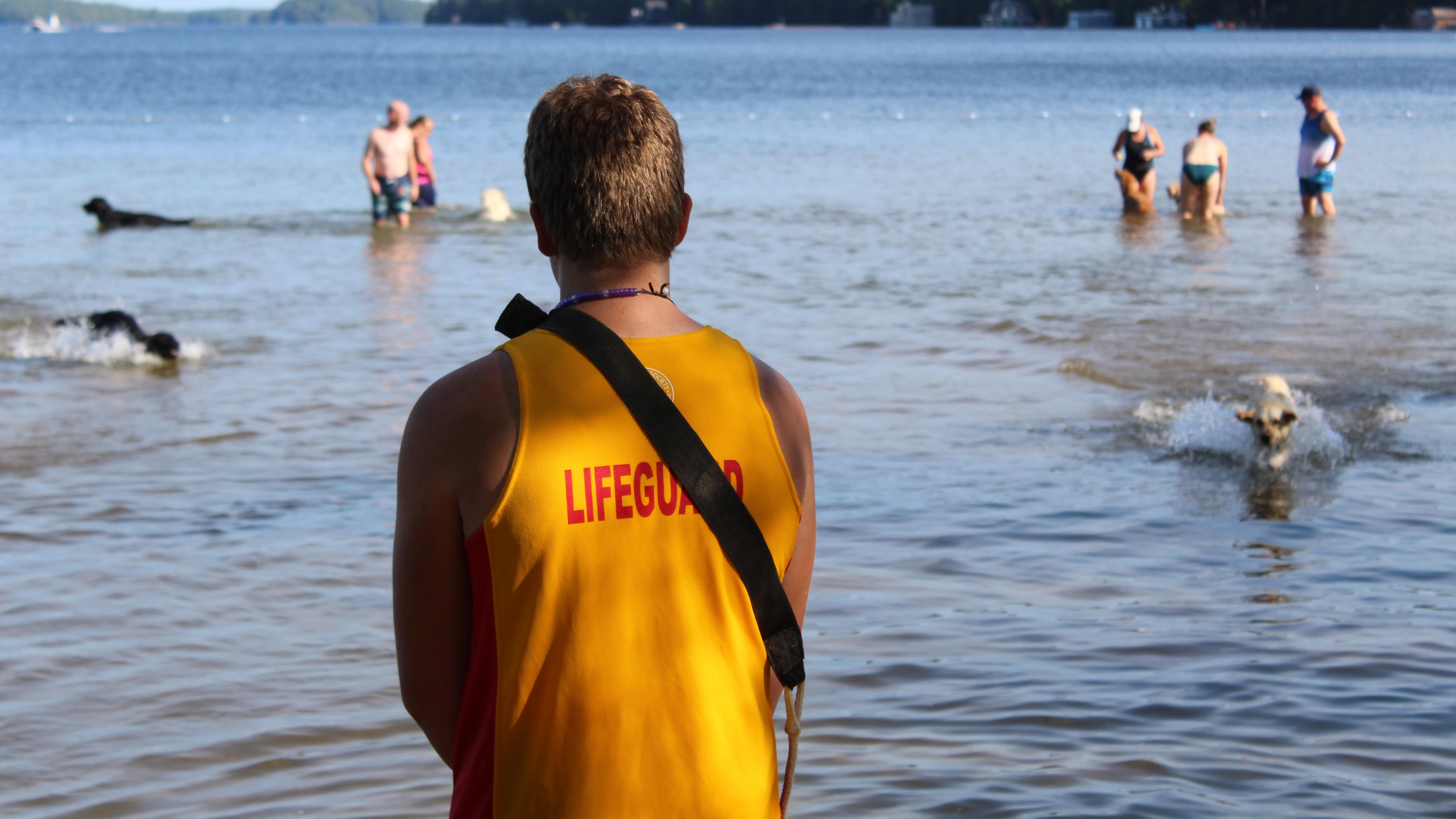 A lifeguard watching the lake while kids are playing