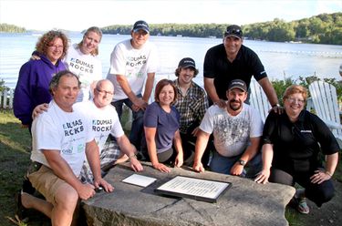 A photo of Dumas Contracting employees sitting at the waterfront at CNIB Lake Joe. 