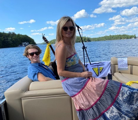 Entertainers Beverley Mahood and Mac Shepherd enjoying a break "between docks" on a pontoon on Lake Joseph