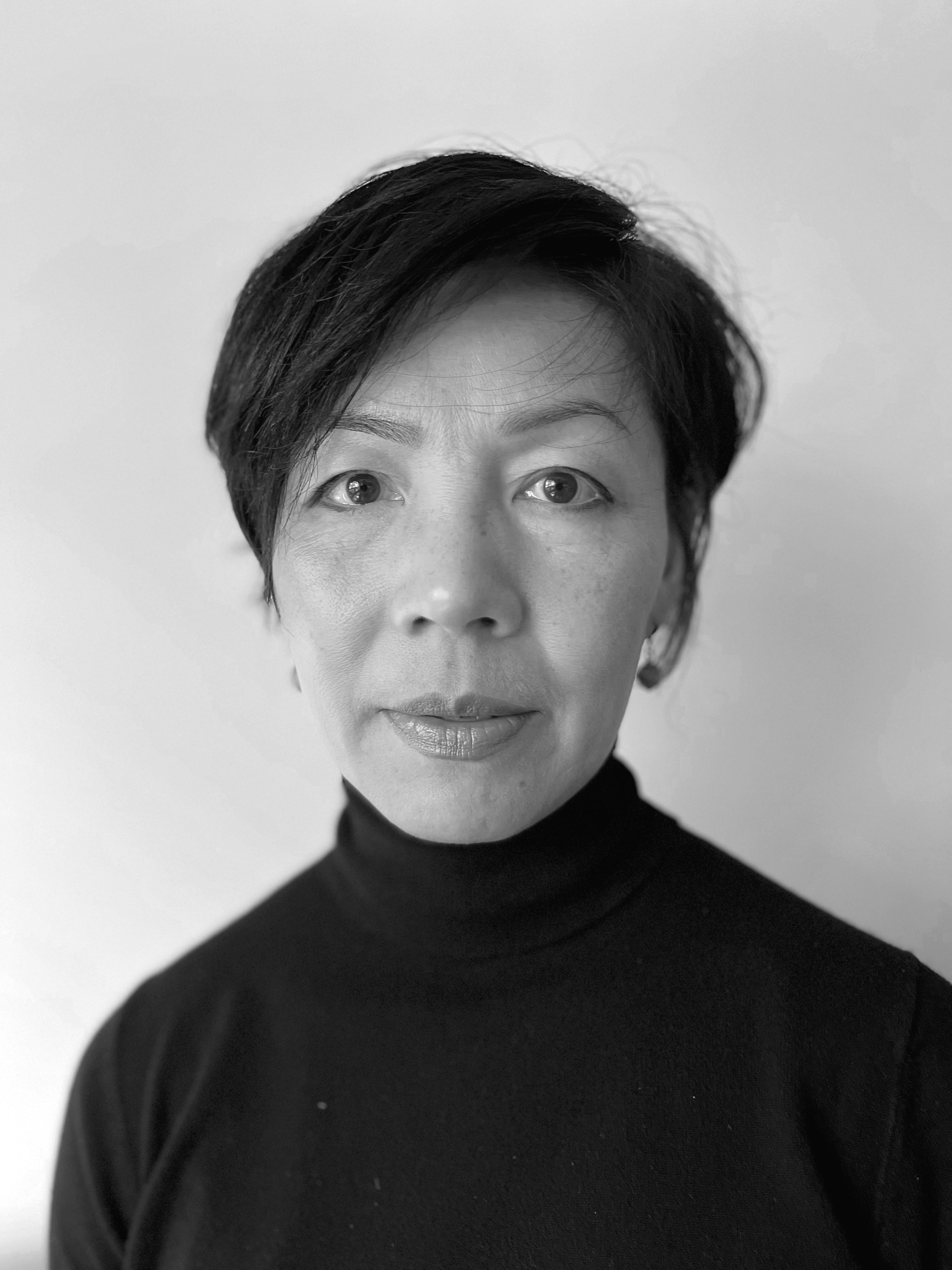 A professional black and white headshot of Nancy Vo. Nancy is wearing a black turtleneck and has short black hair and a calm and neutral facial expression