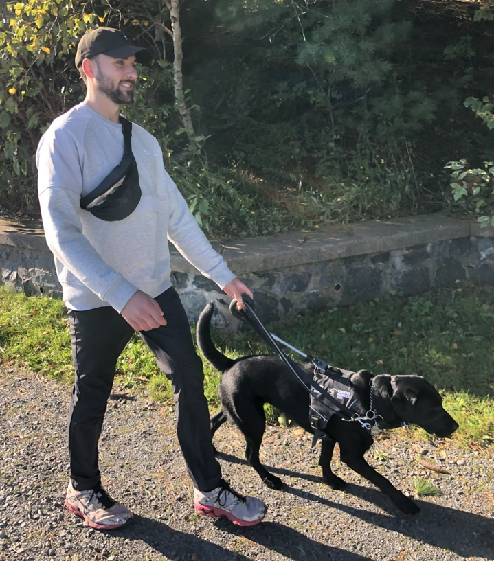 Anton is on a walk with his guide dog, Harper.