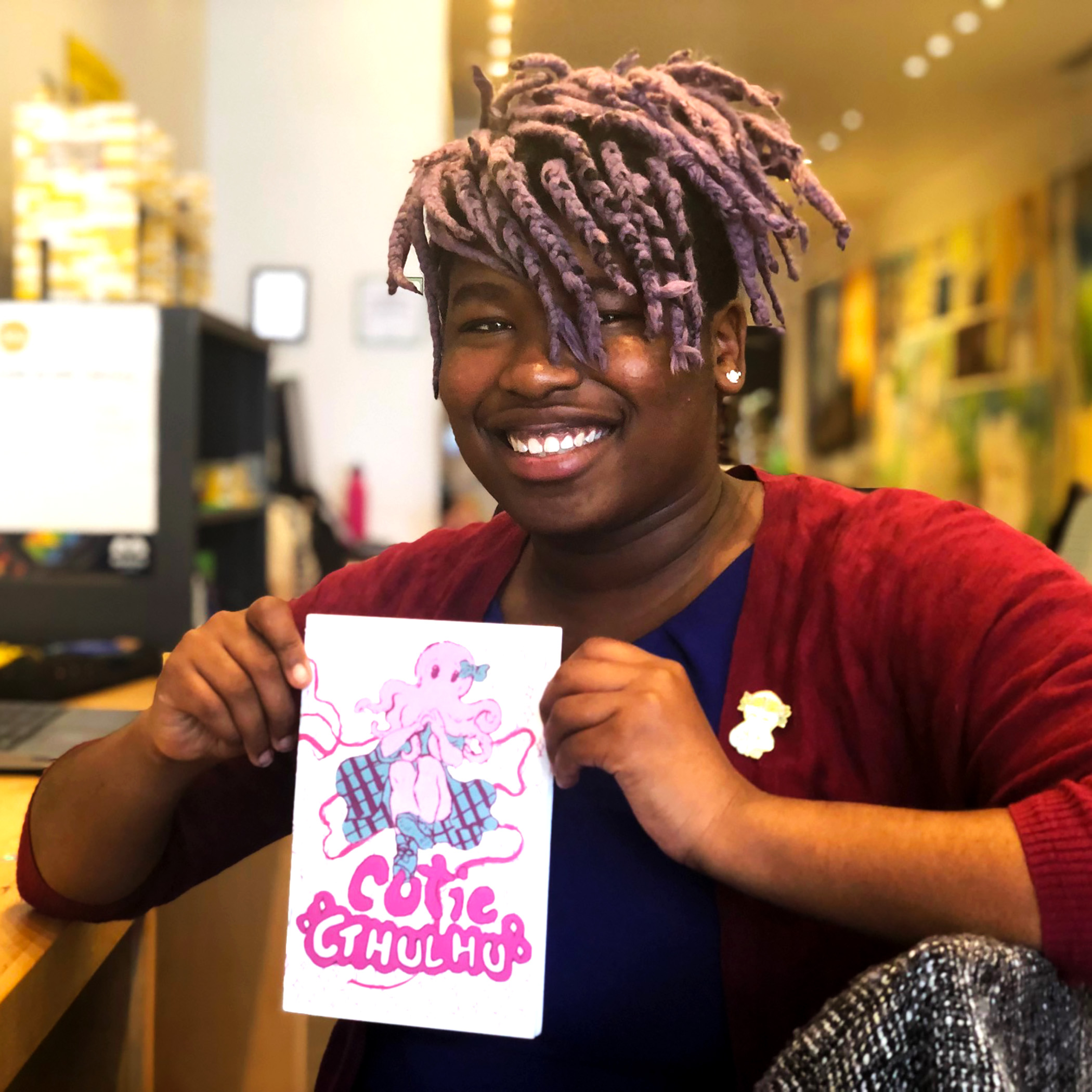 Clover Thursday holds up a comic character she created named Cutie Cthulu.
