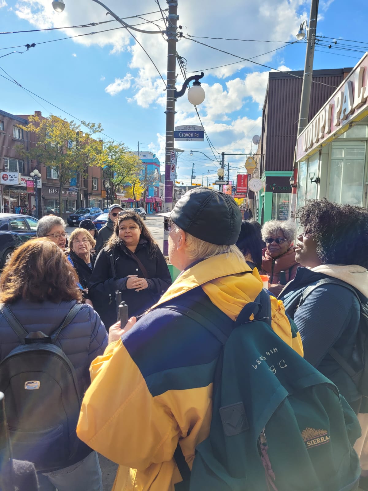  A group of CNIB participants standing outside the Udupi Palace restaurant in Toronto