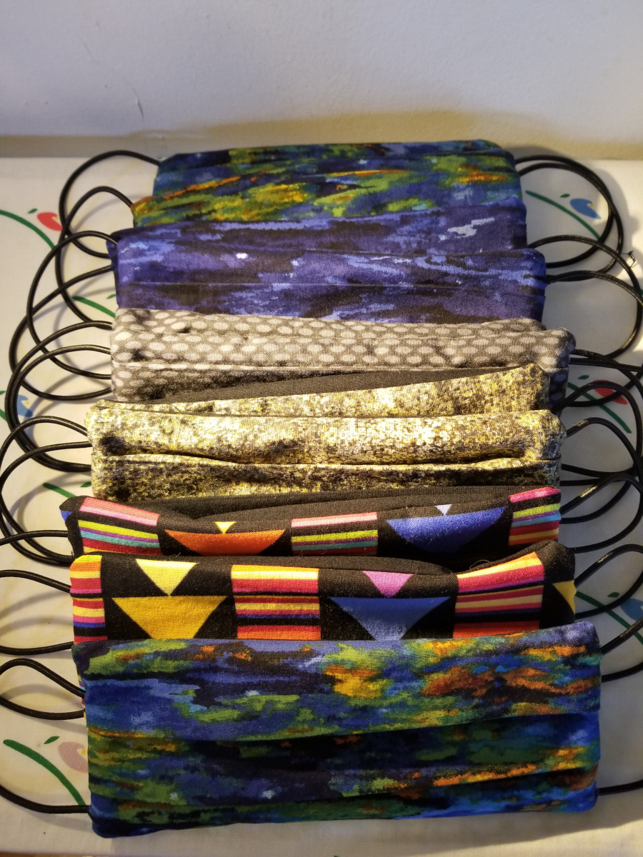 A stack of homemade colourful cloth masks.