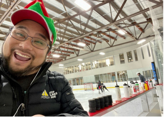Eugène est dans un aréna de hockey local et porte un chapeau d'elfe rouge et vert par-dessus sa casquette de baseball.