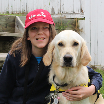 A young boy with his arm around a Golden Retriever.