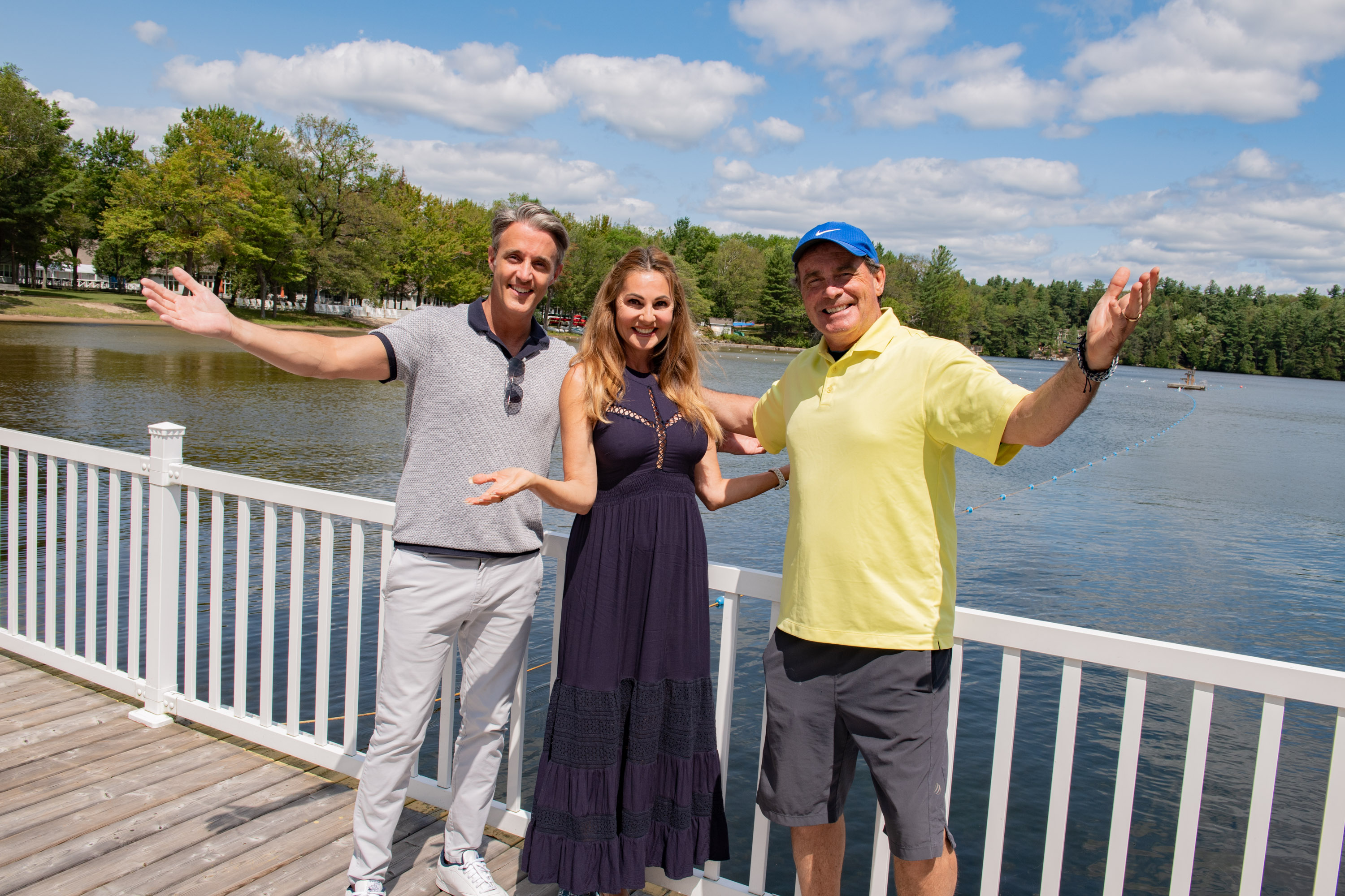 Celebrities Ben Mulroney, Joan Kelly Walker and Rod Black smiling with their arms outstretched on the CNIB Lake Joe dock