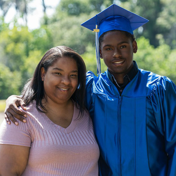 Graduate stands next to his mother 