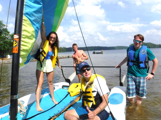 Four people in shorts on catamaran at Lake Joe.