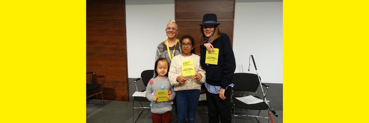 Les lauréats du Concours de création littéraire en braille de 2019 Kelsey, Zara et Zachary posant pour une photo avec Karen Brophey et tenant leurs prix!
