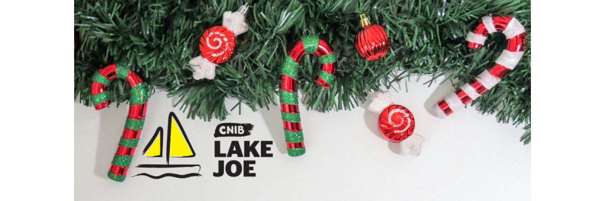 Le logo d'INCA Lake Joe sous une branche de sapin avec des cannes de bonbon et des ornements.