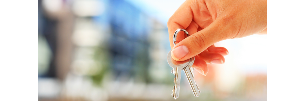 A woman’s right-hand holds a set of apartment keys.