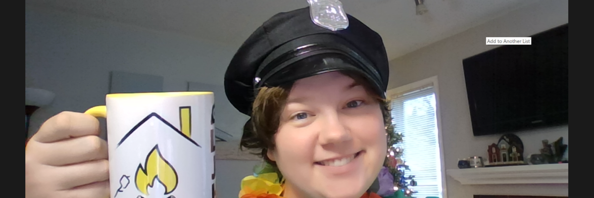 Sam est toute souriante sur l'écran Zoom. Elle porte un képi noir de policier, un lei hawaïen multicolore et tient une tasse à café de la marque LakeJoeINCA@LaMaison.