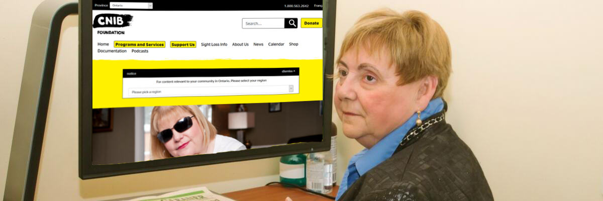 A smiling woman seated at a computer reviews the homepage of the CNIB website