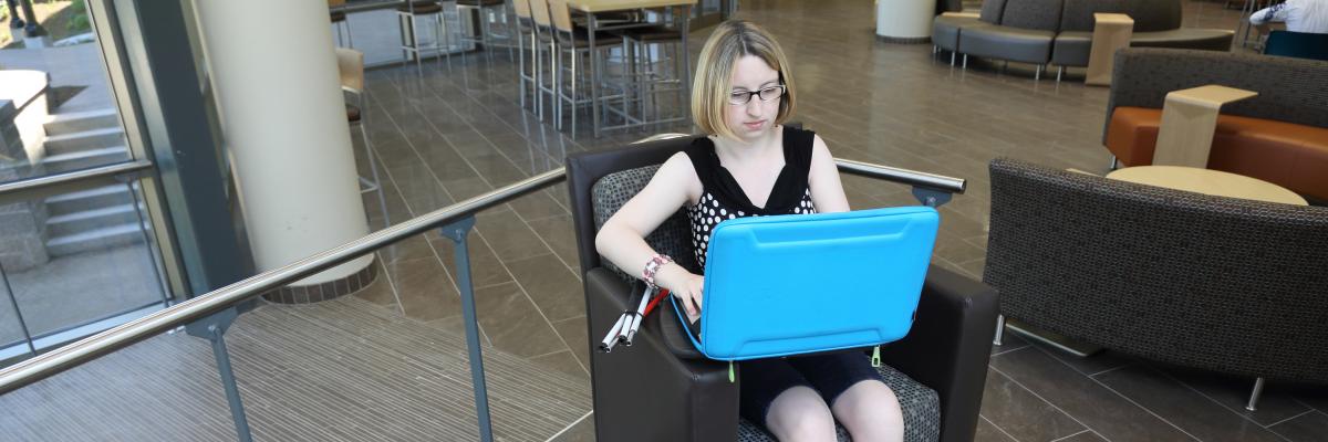 Une jeune femme vivant avec une perte de vision utilise un ordinateur 