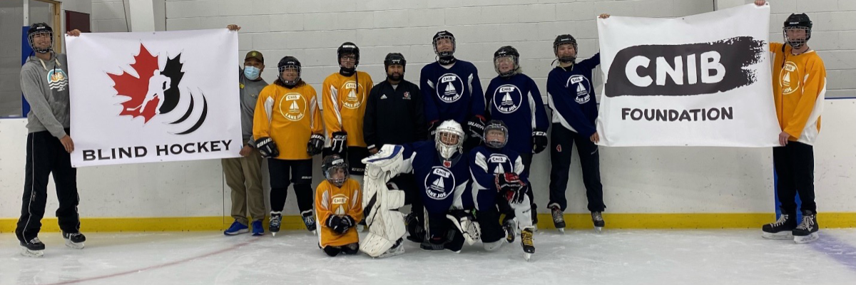 CNIB Lake Joe’s Blind Hockey Team poses for a group photo on the rink after practice with Luca and Eugene