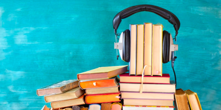 Stacks of books with headphones on top.