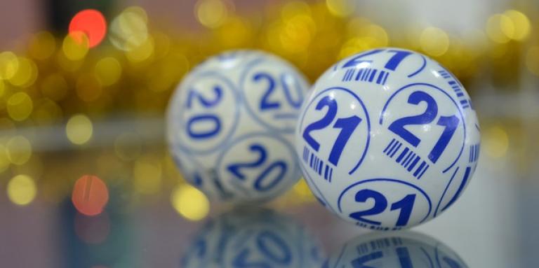 Two  bingo balls imprinted with numbers and letters used in the selection process of a bingo game.