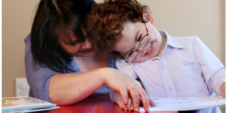 mother and son reading a book in braille 