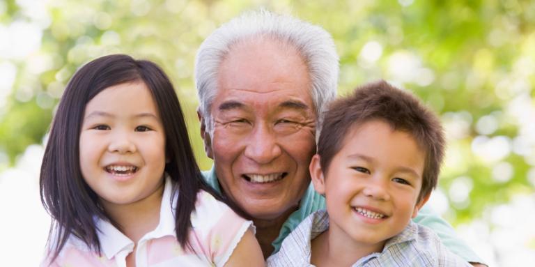 grand-papa souriant photographié avec ses petits-enfants