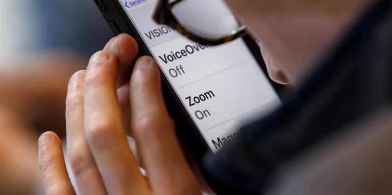 An iPhone 11 screen displays magnified text.