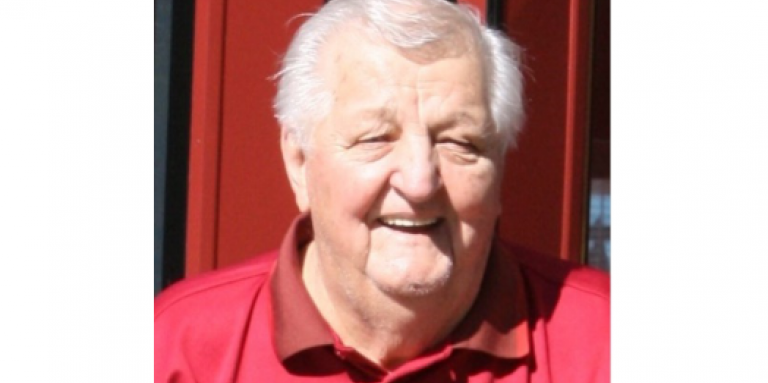 Roy Klementti souriant, portant une chemise de golf rouge