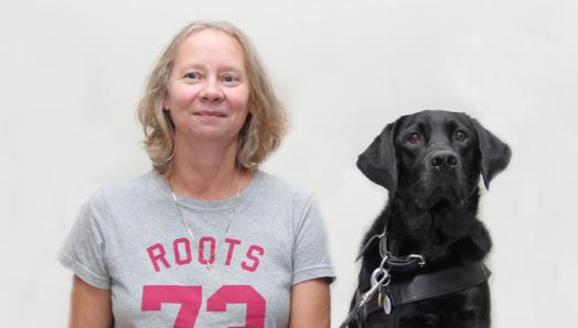 A woman and her black Labrador/Golden Retriever guide dog.