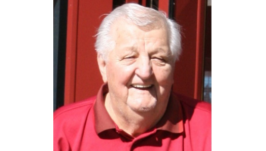 Roy Klementti souriant, portant une chemise de golf rouge