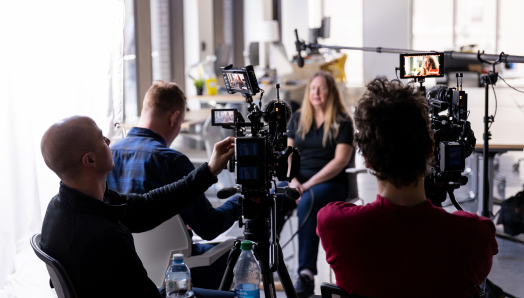 Diane Bergeron est interviewée par une équipe de tournage à INCA Ottawa. L'équipe de trois personnes tient des caméras et des microphones à perche. 
